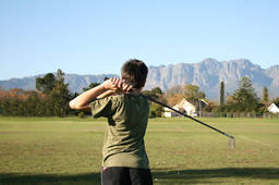 A kid playing golf