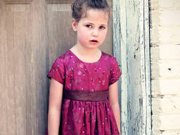A pretty fancy dress with floral designs for a young girl.