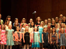A large group of kids singing at their local singing school