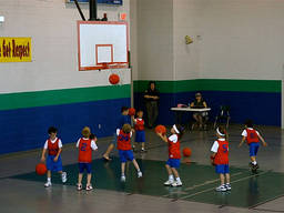 Kindergarten boys and girls score some shots at a basketball camp