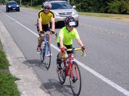 A young boy and his bicycle coach go for a ride in a local highway