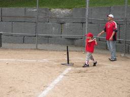 Father and child practice t-ball