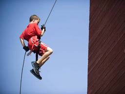 Young boy abseiling from a cliff