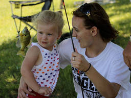 Young girl looks closely at their first catch