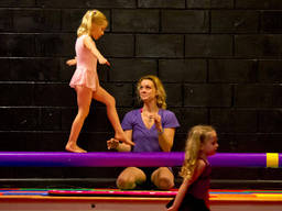 Young girl balancing on a straight, narrow platform