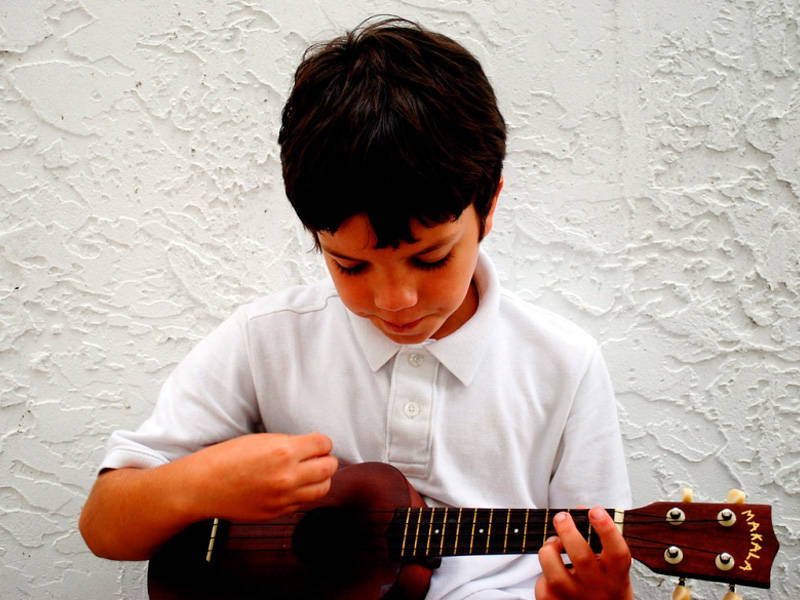 This kid loves strumming his ukulele