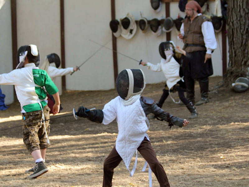 A kid happily showing his fencing skills