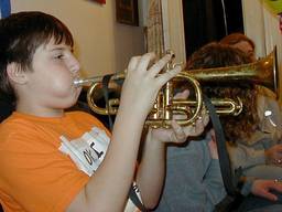 A young boy blowing air into a cornet