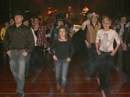 Children and adults learning country dancing together