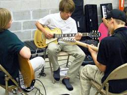Students learning the electric guitar.