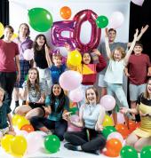 Children and young adults celebrating 50 years with balloons