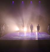 Backlit stage with silhouettes of children around the edges
