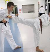Teens practising defense kicks
