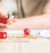 Woman prepares to roll dice across the table