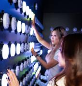 Friends playing an interactive light wall challenge at Power Play Sydney in Sydney CBD