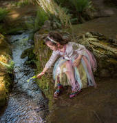 Jessica is mesmerised by the sunlight dancing on the water at Everglades Historic House & Gardens. Photo: David Hill, Headline Publicity