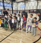 Young children lined up and ready for basketball class, building teamwork and confidence in a fun environment.