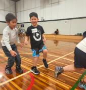 Coach guiding kids through fun basketball drills at Manningham DISC in Donvale — part of the First Pick Basketball holiday camp for ages 4–8.