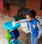 Experiencing the large water/sand wheel for sensory play.