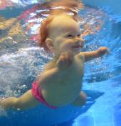 Underwater baby diving during baby swim class