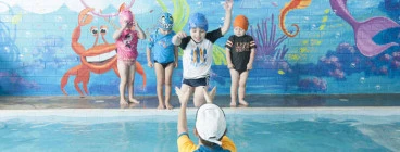 Students enjoy swimming lessons with their friendly instructor
