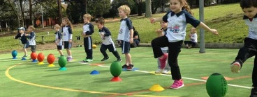 children having fun learning to kick a rugby ball