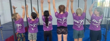 Parkour Gymnasts showing off their 2023 PCYC Gymnastics shirts.