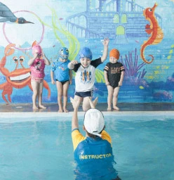 Students enjoy swimming lessons with their friendly instructor
