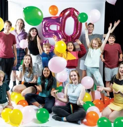 Children and young adults celebrating 50 years with balloons