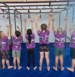 Parkour Gymnasts showing off their 2023 PCYC Gymnastics shirts.