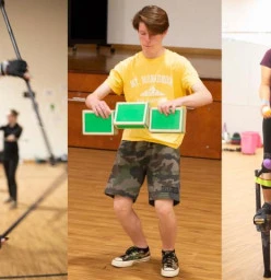 Three individuals in the training hall, one spinning a staff, one trying cigar box juggling, one on stilts