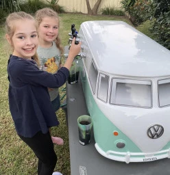Happy kids pouring their own drinks from the mini kombi drink station!