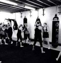 a ladies fitness class punching the bags!